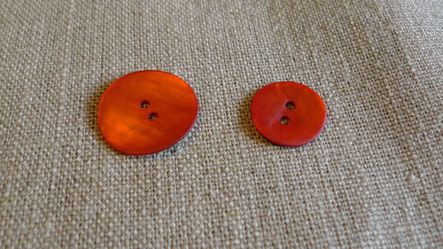 röd pärlemo knapp i två storlekar